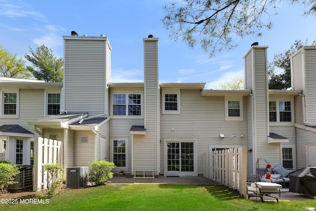 back of house with a patio, central AC unit, a yard, and a chimney