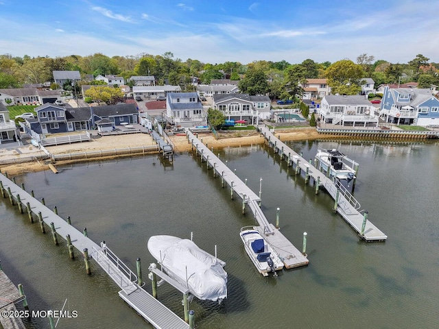 dock area with a residential view, boat lift, and a water view