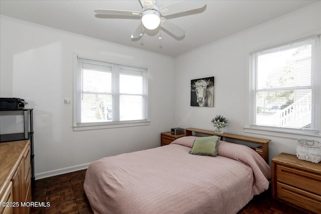 bedroom with crown molding, a ceiling fan, baseboards, and multiple windows