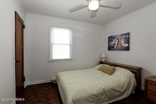 bedroom with baseboards, ornamental molding, and ceiling fan