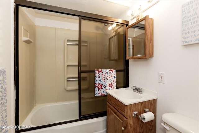 bathroom with vanity, shower / bath combination with glass door, and toilet