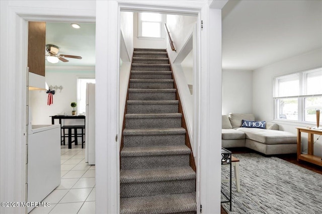 staircase featuring tile patterned flooring and ceiling fan