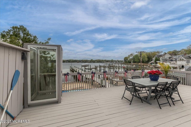 wooden deck featuring outdoor dining space and a water view