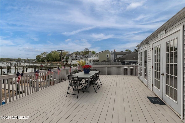 wooden deck featuring french doors, outdoor dining space, and a residential view