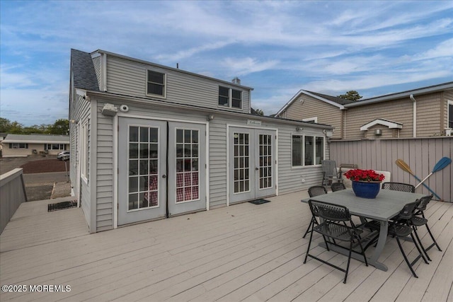 wooden terrace with french doors and outdoor dining area