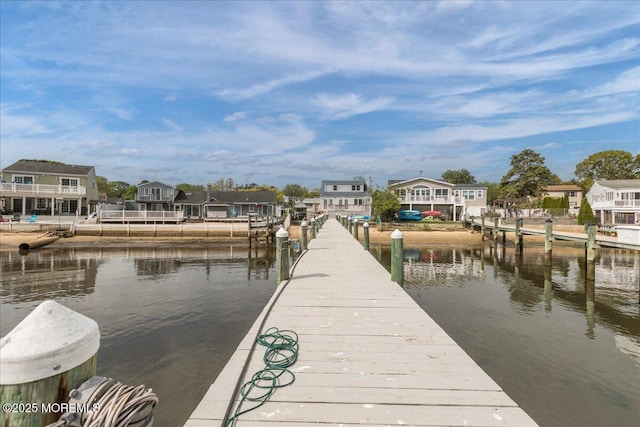 view of dock with a water view and a residential view