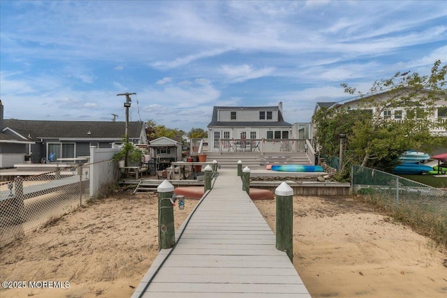 dock area with a fenced backyard and a wooden deck