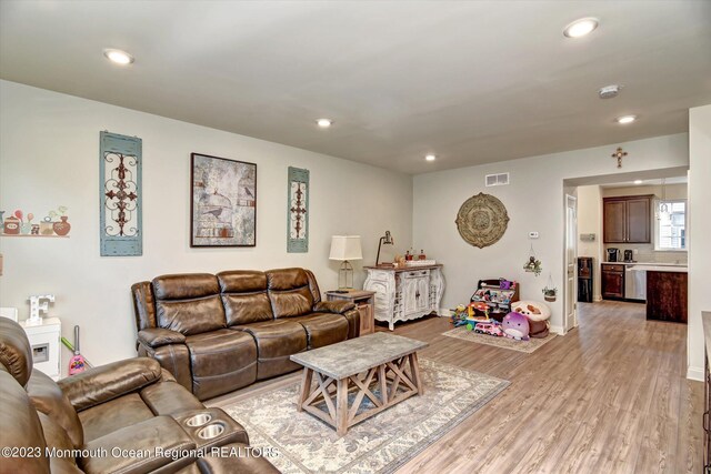 living area with recessed lighting, light wood finished floors, and visible vents