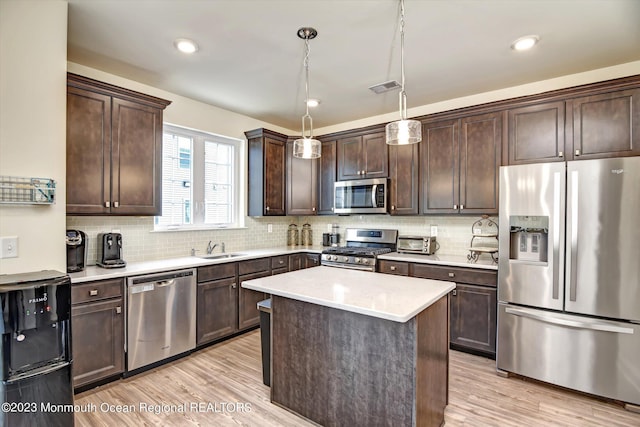kitchen featuring light countertops, stainless steel appliances, dark brown cabinetry, and visible vents