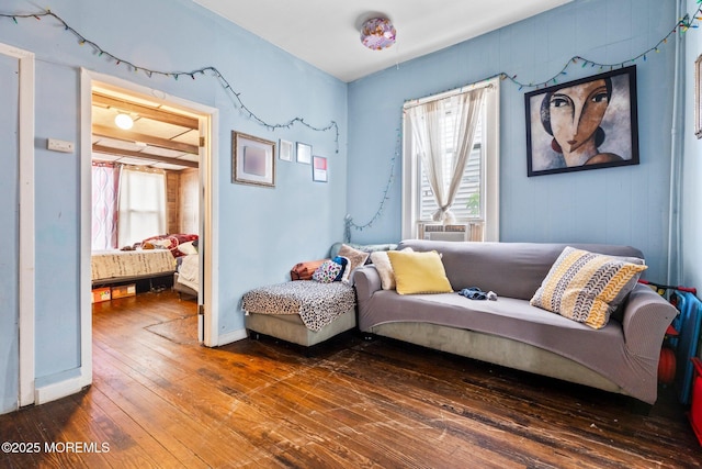 living area with healthy amount of natural light, hardwood / wood-style flooring, and baseboards