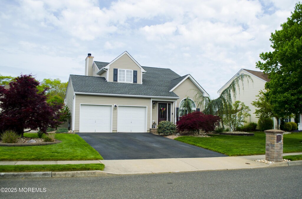 18 Gettysburg Dr, Howell, NJ 07731 - view of front of property with a garage, driveway, a front lawn, a chimney, and roof with shingles