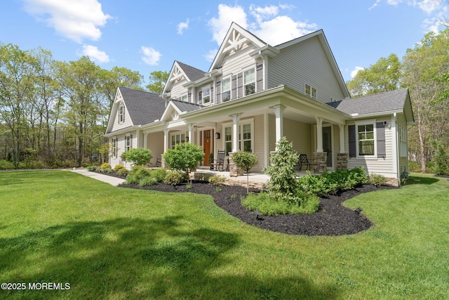 view of front of property featuring a front yard, roof with shingles, and a porch