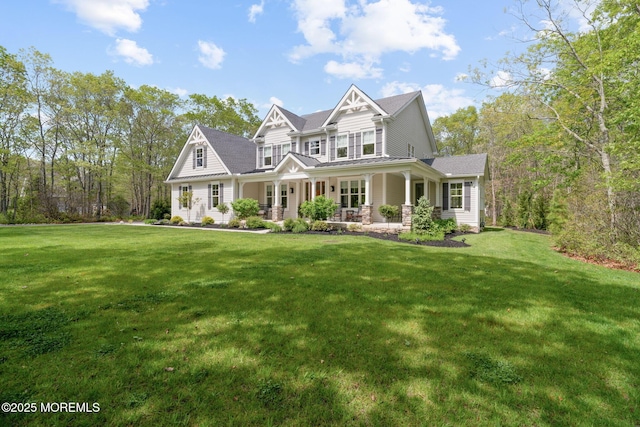 view of front of home featuring covered porch, a front yard, and a standing seam roof