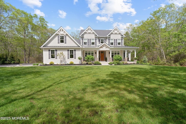 craftsman-style home with a porch, a standing seam roof, a front lawn, and metal roof