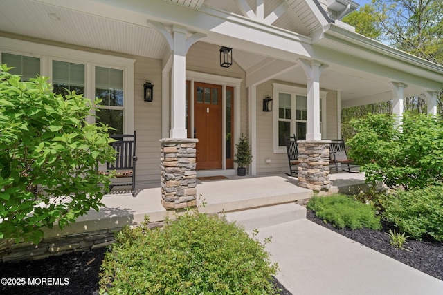 entrance to property featuring a porch and stone siding