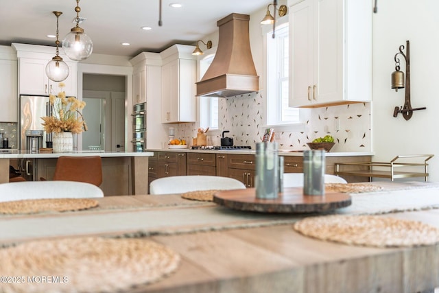 kitchen featuring premium range hood, light countertops, white cabinets, and recessed lighting