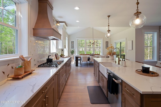kitchen featuring appliances with stainless steel finishes, premium range hood, a sink, plenty of natural light, and recessed lighting