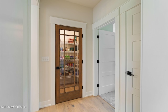 doorway to outside featuring light wood-style floors and baseboards