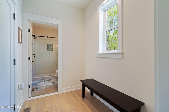 corridor with light wood-style flooring and baseboards