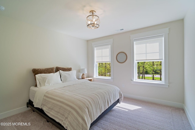 bedroom featuring carpet flooring, baseboards, and a chandelier