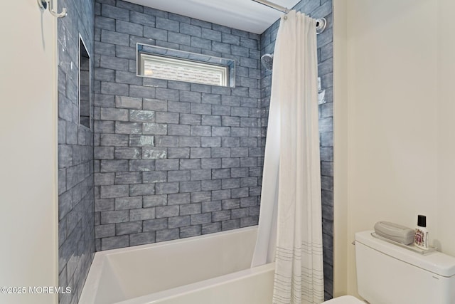 bathroom featuring toilet and shower / bath combination with curtain