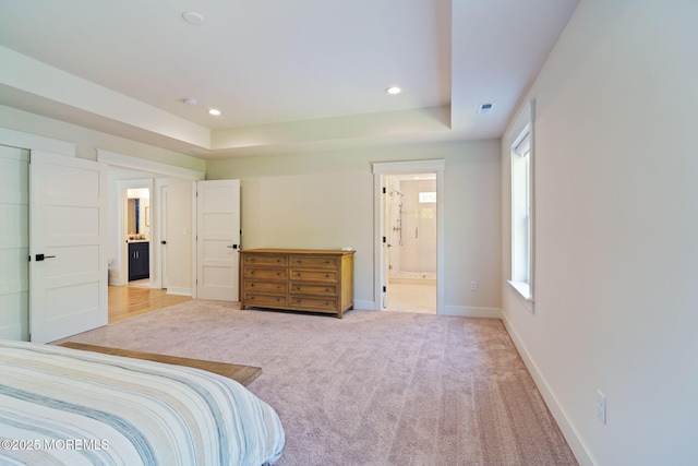 bedroom with ensuite bathroom, recessed lighting, baseboards, carpet flooring, and a tray ceiling
