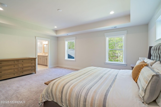 bedroom featuring light colored carpet, multiple windows, a raised ceiling, and recessed lighting