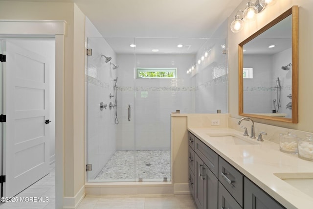 bathroom featuring a shower stall, double vanity, and recessed lighting