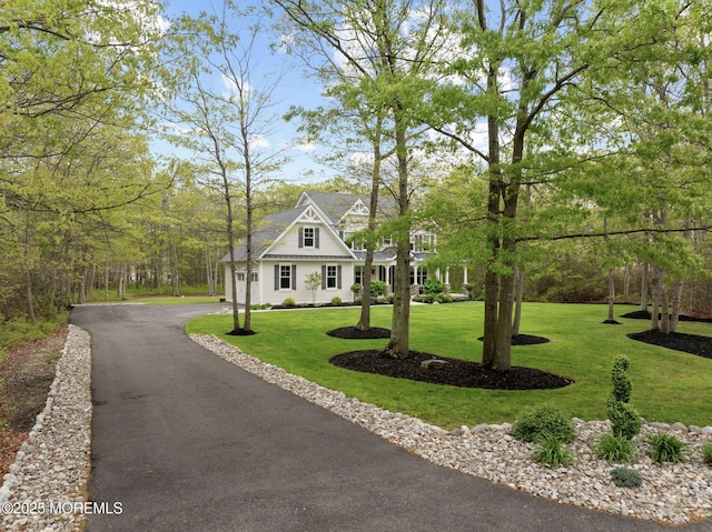 view of front of home with asphalt driveway, a front yard, and a garage