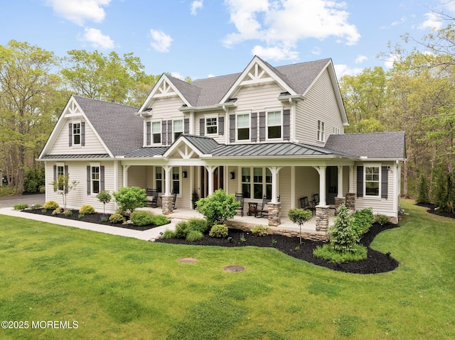 craftsman inspired home featuring a standing seam roof, roof with shingles, and a front yard