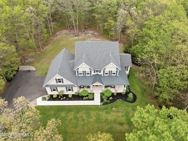 aerial view of property and surrounding area featuring a heavily wooded area