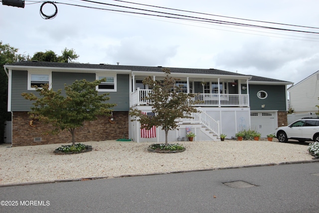 view of front of property featuring stairs, an attached garage, a porch, and brick siding