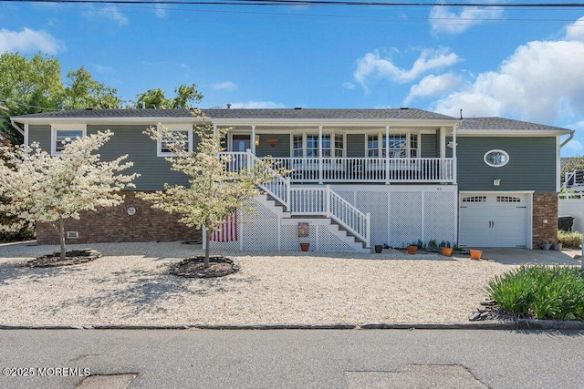 view of front of house featuring a porch, an attached garage, stairs, and brick siding