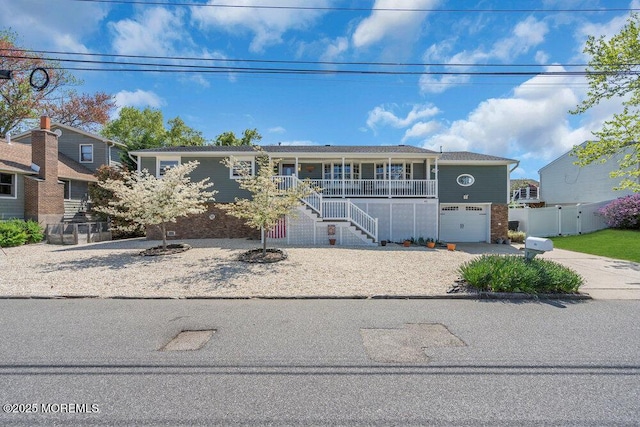 view of front facade featuring fence, stairs, an attached garage, a porch, and concrete driveway