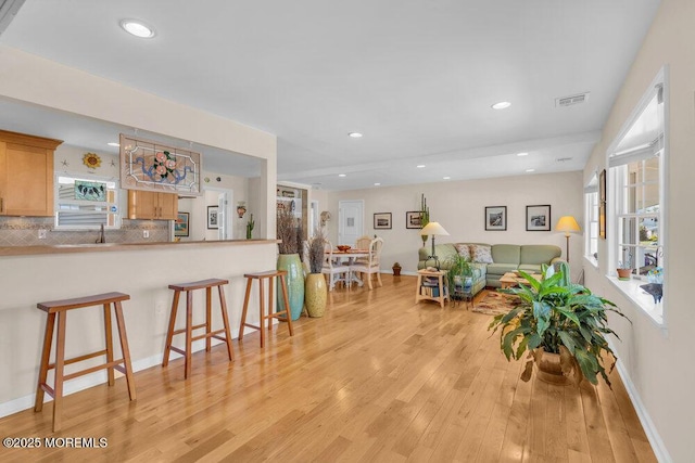 living room featuring visible vents, recessed lighting, light wood finished floors, and baseboards