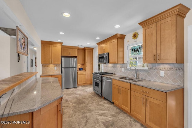 kitchen featuring light stone counters, a sink, stainless steel appliances, recessed lighting, and tasteful backsplash