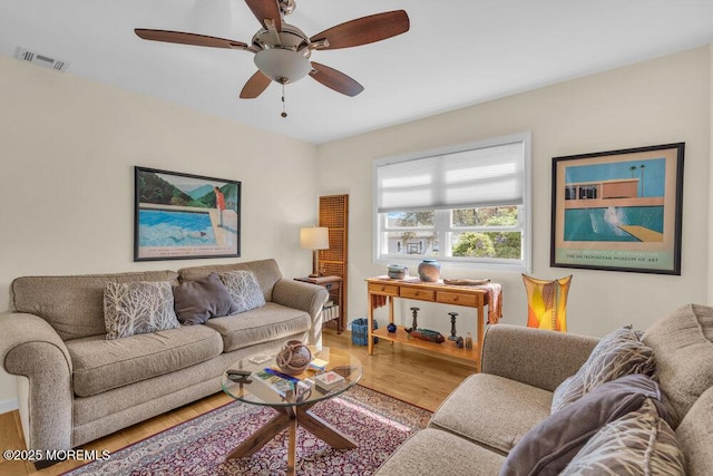 living room featuring a ceiling fan, wood finished floors, and visible vents