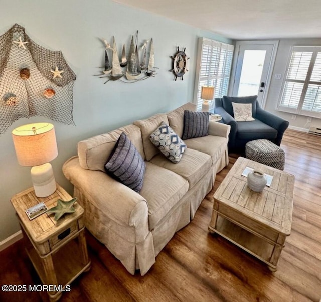 living area with baseboards and wood finished floors