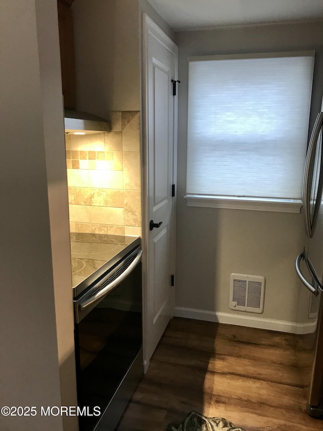 doorway to outside featuring dark wood-style flooring, baseboards, and visible vents