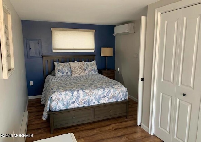 bedroom with baseboards, a wall mounted AC, and wood finished floors