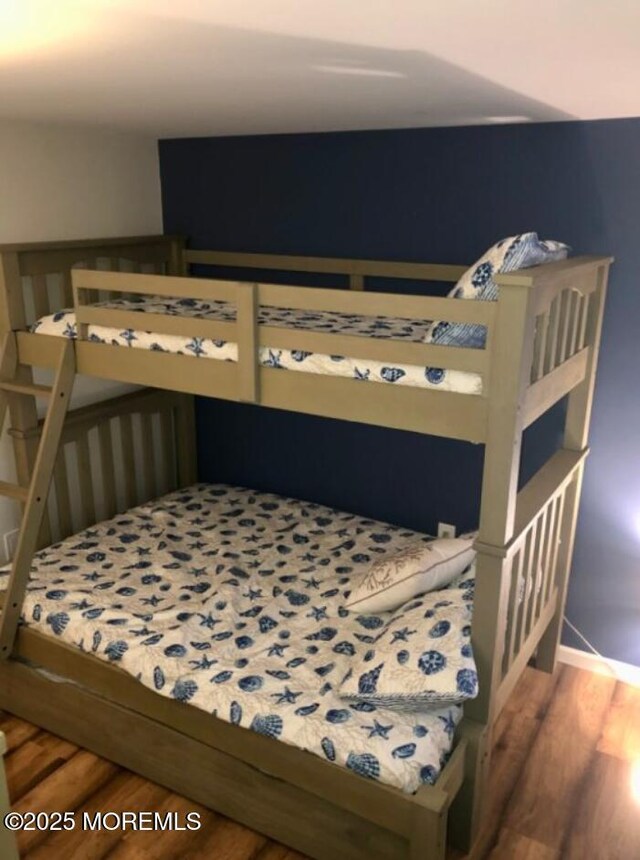 bedroom with baseboards and wood finished floors
