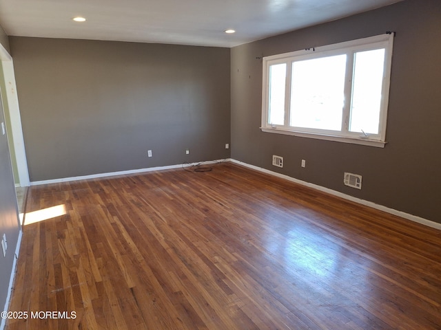 unfurnished room with visible vents, recessed lighting, baseboards, and wood finished floors