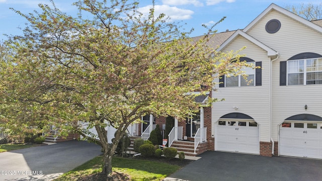 view of front of house featuring an attached garage, aphalt driveway, and brick siding
