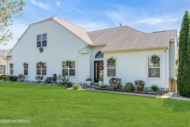view of front of home featuring a front yard and roof with shingles