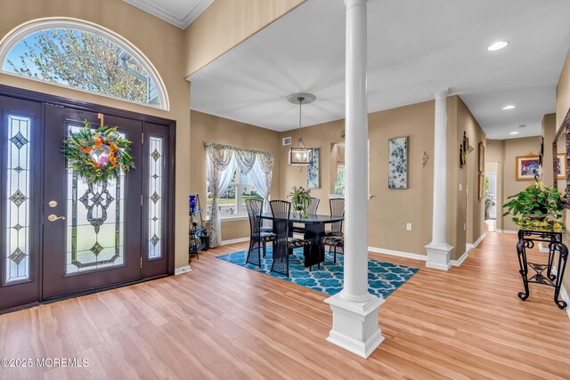 entrance foyer with ornate columns, baseboards, wood finished floors, recessed lighting, and crown molding