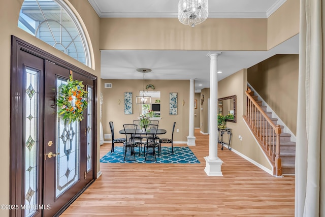 dining space with ornate columns, light wood-style floors, baseboards, and stairway