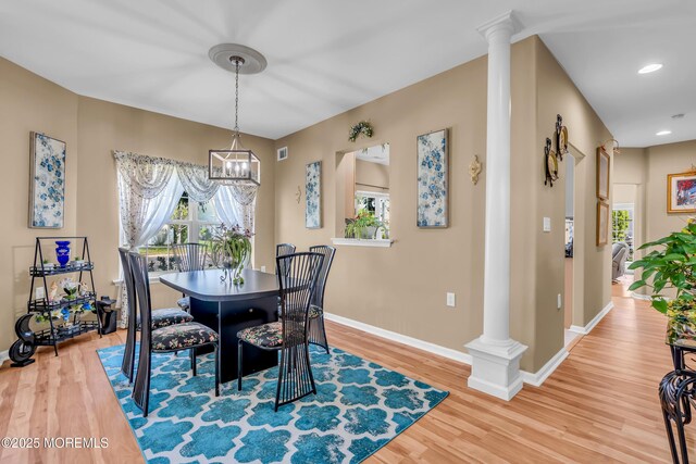dining room with ornate columns, baseboards, light wood-style floors, a chandelier, and recessed lighting