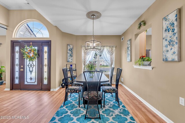 dining space featuring a chandelier, wood finished floors, and plenty of natural light