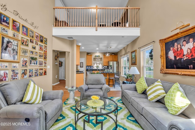 living room with light wood-style floors and a high ceiling