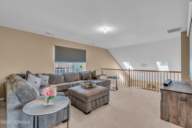 living area with light colored carpet, a skylight, and vaulted ceiling